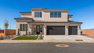 Prairie-style home with a tile roof, stucco siding, concrete driveway, and an attached garage