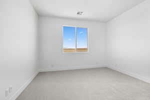 Empty room featuring light carpet and baseboards