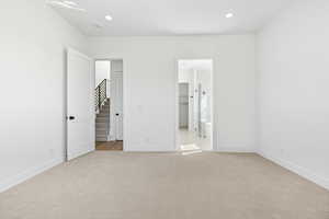 Unfurnished bedroom with light colored carpet, recessed lighting, and a spacious closet
