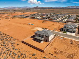 Aerial perspective of suburban area featuring a mountainous background and a desert landscape