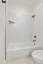 Full bath featuring shower / washtub combination and tile patterned flooring