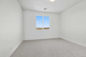 Spare room featuring baseboards and light colored carpet