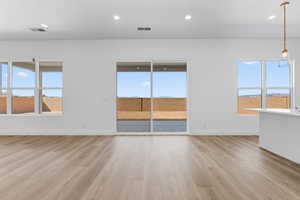 Empty room featuring light wood finished floors and recessed lighting