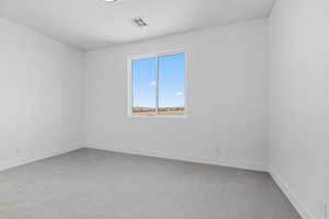 Empty room featuring light carpet and baseboards