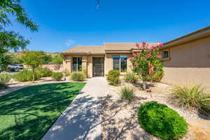 View of front facade featuring stucco siding and a front lawn