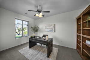 Carpeted office featuring baseboards and ceiling fan