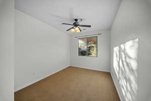 Unfurnished room featuring carpet floors and ceiling fan