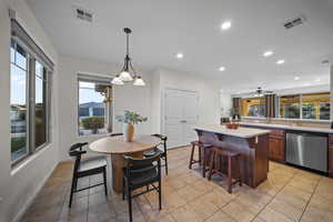 Dining room featuring light tile patterned floors, recessed lighting, plenty of natural light, a ceiling fan, and a chandelier