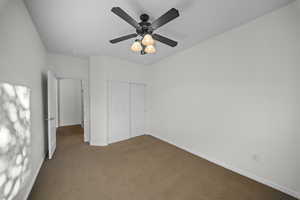 Unfurnished bedroom with carpet flooring, a closet, and ceiling fan
