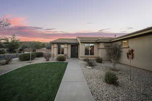 View of front of house featuring stucco siding and a tile roof