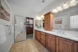 Full bath with double vanity and light tile patterned floors