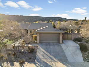 Ranch-style home with a gate, a mountain view, driveway, and an attached garage