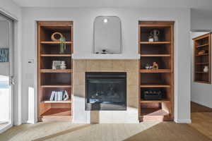 Carpeted living area featuring a fireplace and built in features