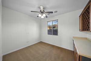 Unfurnished office with carpet floors and a ceiling fan