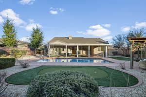 View of swimming pool featuring an area to practice putting, a patio, and a fenced backyard