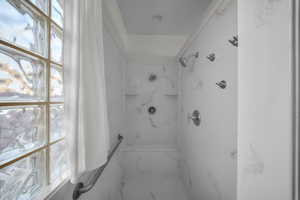 Full bathroom with a marble finish shower