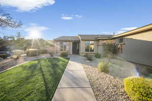 Doorway to property featuring stucco siding and a yard