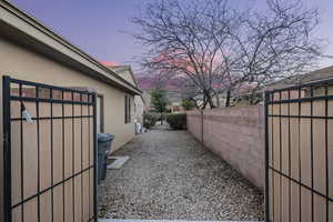 Property exterior at dusk featuring stucco siding and a gate