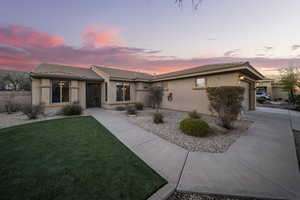 View of front of home with stucco siding, a garage, a tiled roof, and driveway