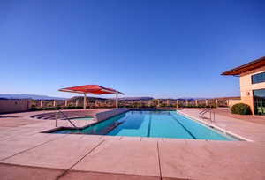Community pool featuring a mountain view, a patio area, and a hot tub