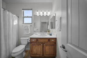 Bathroom with vanity, curtained shower, and dark tile patterned flooring