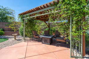 Fenced backyard with a patio, an outdoor fire pit, and a pergola