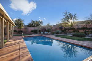 View of pool featuring a patio area, a gazebo, a fenced backyard, and a putting green