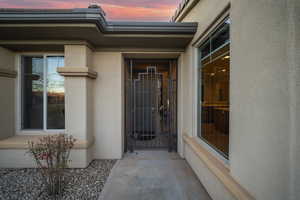 Exterior entry at dusk featuring stucco siding