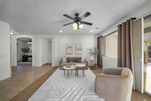 Living room with a ceiling fan, recessed lighting, light tile patterned floors, and arched walkways