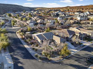 Aerial view of property and surrounding area with a mountainous background and nearby suburban area