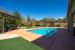 View of swimming pool featuring a patio area, a fenced backyard, and a pergola