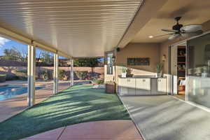 Fenced backyard featuring area for grilling, a ceiling fan, and a patio area
