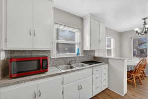 Kitchen with white cabinetry, light wood-style LVP floors, and light countertops