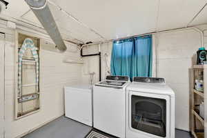 Laundry room with concrete floors and independent washer and dryer