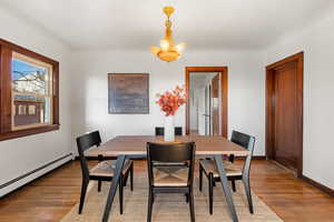 Dining room with wood finished floors and baseboard heating