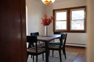 Dining area with wood-type flooring and arched walkways
