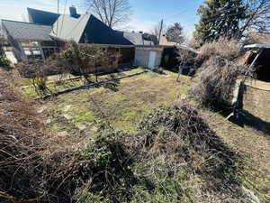 View of green lawn featuring a storage shed