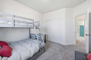 Carpeted bedroom featuring baseboards and a closet