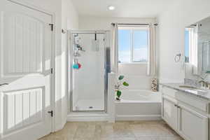 Bathroom with a garden tub, a stall shower, vanity, and recessed lighting
