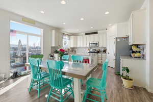 Dining room with wood finished floors, recessed lighting, and a textured ceiling