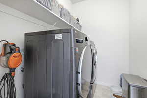 Washroom featuring independent washer and dryer and baseboards
