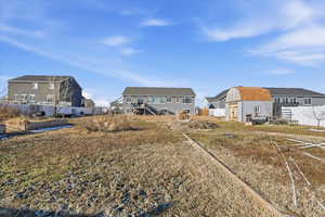 Rear view of property featuring a residential view, an outdoor structure, and stairway