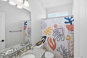 Bathroom featuring curtained shower and vanity