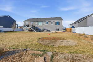 Rear view of property with stairs, a fenced backyard, and stucco siding