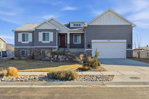 Craftsman house with stone siding, board and batten siding, concrete driveway, and a shingled roof