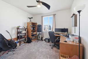 Home office with light carpet, ceiling fan, and vaulted ceiling