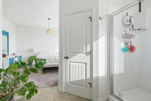 Bathroom with a shower stall, ensuite bath, light tile patterned floors, and light colored carpet