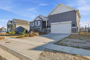 View of front of property featuring stone siding, board and batten siding, and driveway