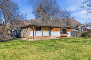 Back of property with brick siding and covered porch