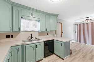 Kitchen featuring green cabinetry, light countertops, and dishwasher